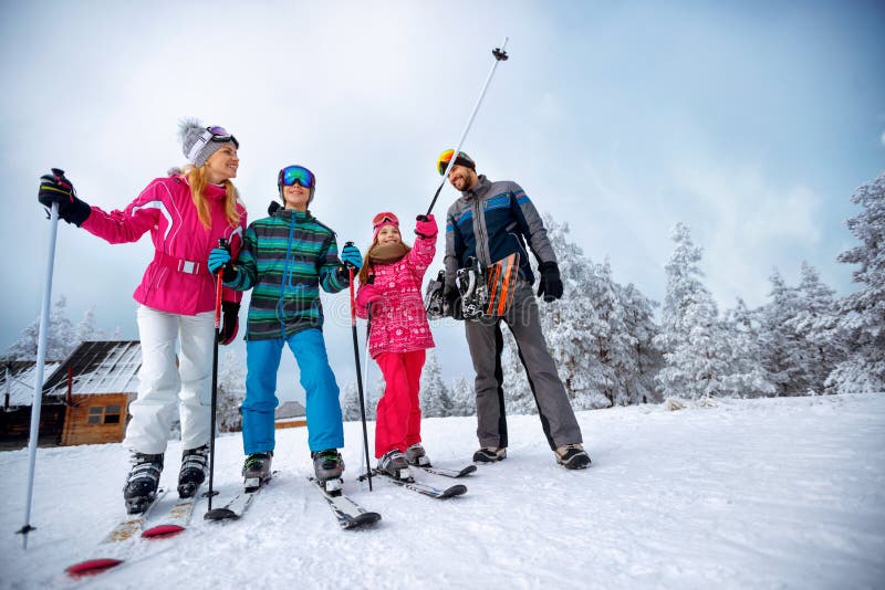 Winter time and skiing - family with ski and snowboard on ski ho